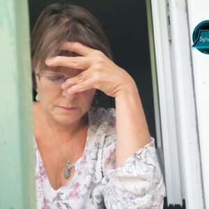 Femme pensive la main sur le front, exprimant la fatigue et la souffrance intérieure liées à une relation toxique.