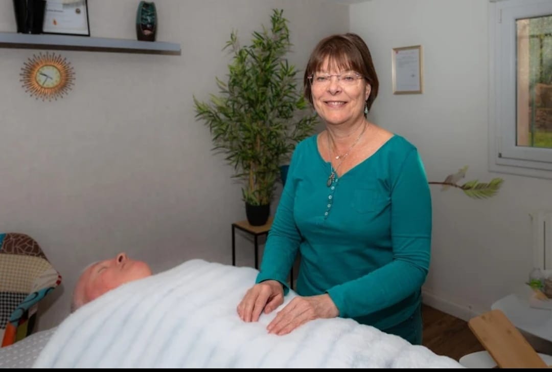 Praticienne Reiki réalisant une séance énergétique dans un cabinet apaisant.
