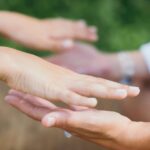 Mains en approche lors d’une séance Reiki illustrant l’énergie et l’harmonisation.